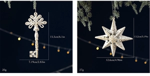 Detailed cream star and key ornaments with golden glitter hanging on Christmas tree
