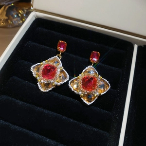 Macro detail of French vintage earrings with red square gemstones and golden beads