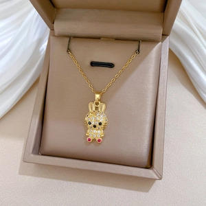 Detailed macro view of gold rabbit pendant with sparkling crystals and red gemstone eyes
