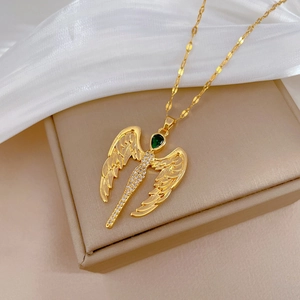 Golden wing necklace with green teardrop gem and diamonds on beige jewelry box