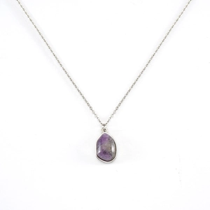 Detailed close-up of purple natural stone pendant on a silver irregular geometric necklace