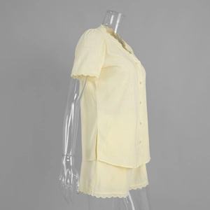 Détail de la dentelle festonnée sur le col en V et les manches de cet ensemble jaune