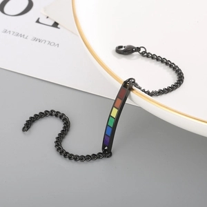 Detail of black curb chain bracelet with rainbow enamel plate and lobster clasp