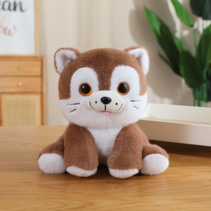 Close-up of cute plush cat toy with big orange eyes and soft fur on a wooden table