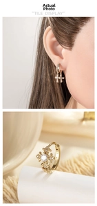 Close-up of vintage gold cross hoop earrings with inlaid zircons and engraved details