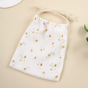 Detail of floral printed muslin cotton drawstring bag with beige rope closure and soft texture