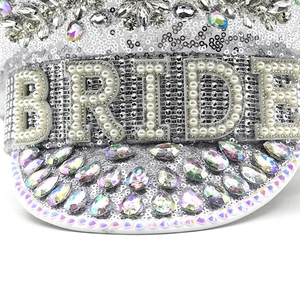 Nahaufnahme von silbernen Pailletten und Perlen-Schriftzug BRIDE auf dem Braut-Hut