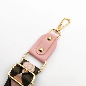 Detail of pink diamond pattern canvas strap with gold swivel snap hook and rivets