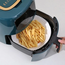 Disposable air fryer paper liner showing crispy French fries in a deep green fryer