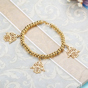 Golden beaded elastic bracelet featuring three hollow Hamsa Hand charms in stainless steel