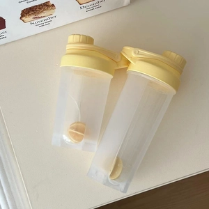 Translucent white dual-chamber protein shaker bottle with scale and cream yellow lid