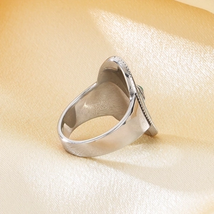 Detailed view of bohemian vintage stainless steel ring with oval green stone inlay