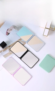 Detailed view of portable double-sided folding makeup mirrors in four pastel colors
