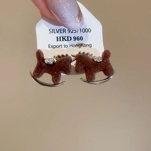 Close-up of brown flocked rocking horse earring with tiny crystals and silver finish