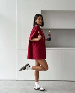 Détail d'un t-shirt oversize bordeaux avec motif texturé de cœurs en relief 3D