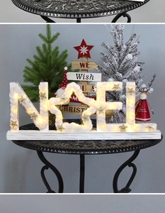 Close-up of wooden NOEL Christmas letter sign with warm LED lights on a table