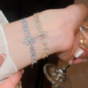 Gros plan d'un bracelet fleuri étincelant avec zircons en finitions or et argent au poignet