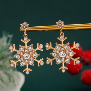Detailed view of gold snowflake earrings with pearls and rhinestones on a festive background