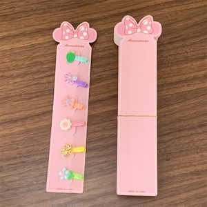 Pink display card featuring six colorful kids hair clips on a wooden tabletop