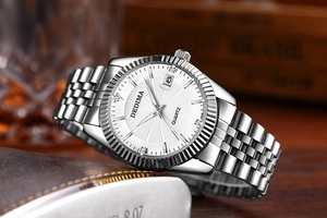 Macro shot of quartz watch with fluted bezel, date window, and silver link bracelet