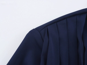 Detailed view of the pleated navy blue satin fabric showing fine texture and folding design