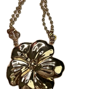 Golden flower pendant necklace with bead chain shown on a minimalist white background