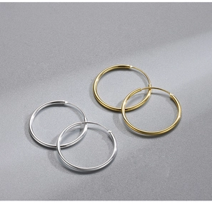Flat lay of minimalist S925 sterling silver hoop earrings in gold and silver finishes