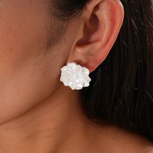 Gros plan de boucles d'oreilles fleurs blanches sur modèle avec texture perlée élégante