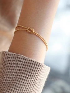 Close-up of a gold Mobius knot S925 sterling silver bracelet on a woman's wrist