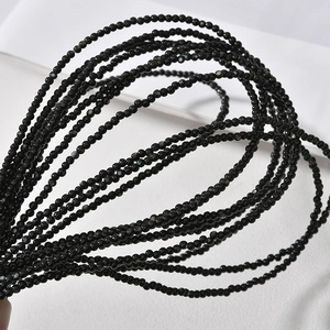 Macro shot of 2mm small round black shell beads strand for DIY jewelry making