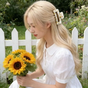 Pinza per capelli quadrata con api e fiori, indossata da una modella in un giardino