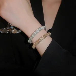 Sparkling diamond-encrusted twisted open bangle in gold and silver finish for women