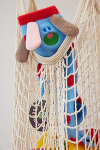 Close-up of blue coral fleece sock with red polka dots and cartoon dog in a net bag