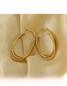 Detail of 18k gold plated titanium steel hoop earrings on a luxury silk background