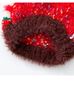 Close-up of winter pet sweater showing red knitted fabric and faux fur trim detail