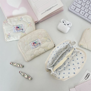 Quilted cream zippered organizer pouch with embroidered details and multi-layer storage