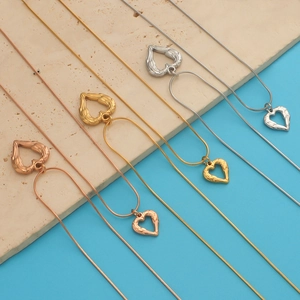 Detailed view of heart-winged pendants in rose gold, gold, and silver finishes