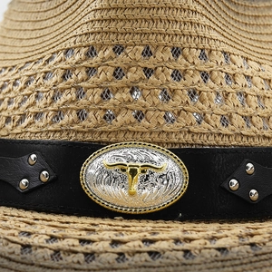 Close-up of woven straw cowboy hat featuring black leather band and metal bull buckle