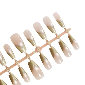 Luxurious champagne gold V-shape tip press-on nails with a soft pink base in coffin shape