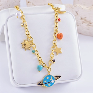 Detail of gold planet necklace with purple heart, sun, and moon charms on jewelry box