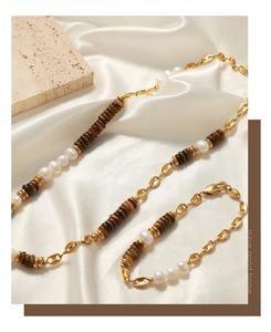 Detail of tiger eye stone and pearl necklace with golden pig nose link chain and bracelet