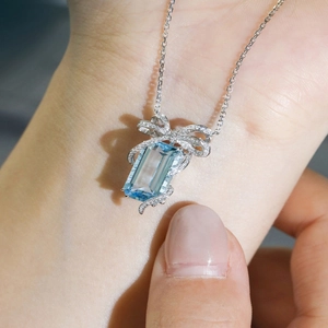 Princess cut blue topaz necklace with diamond bow pendant on a delicate chain