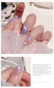 Close-up of heart-shaped iridescent nail charms in pink, purple, and blue hues
