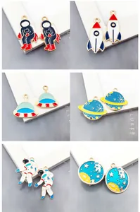 Close-up of enamel astronaut and rocket charms showing dimensions and alloy texture
