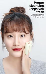 Detailed view of yellow oil absorbing tissue being applied to a model's face for skincare