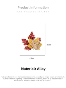 Macro detail of maple leaf brooch featuring red and yellow enamel on gold alloy metal