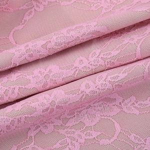 Primer plano de tela de encaje rosa con delicados motivos florales y textura de malla del traje