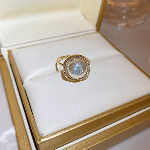Macro detail of cat eye stone and pearl ring with micro-diamond pavé in a jewelry box