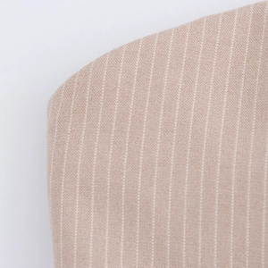 Macro view of beige pinstripe woven fabric detail on the pleated blazer dress