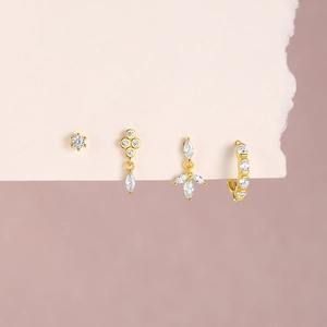 Detail of four gold S925 silver earrings with sparkling white marquise cubic zirconia